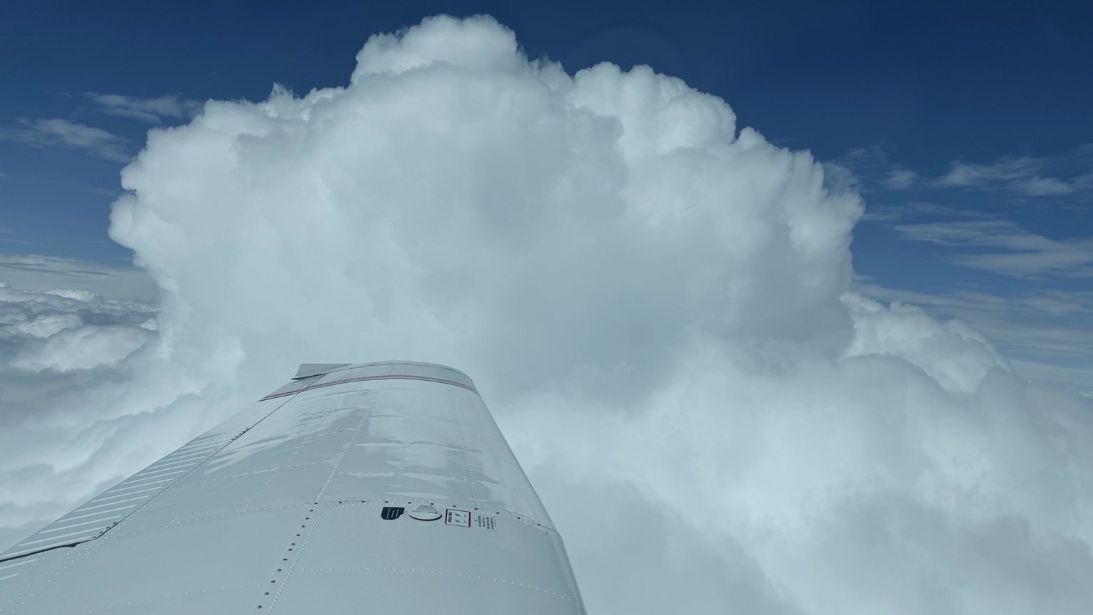 Piper-Flügel neben Wolkenaufbau im Reiseflug